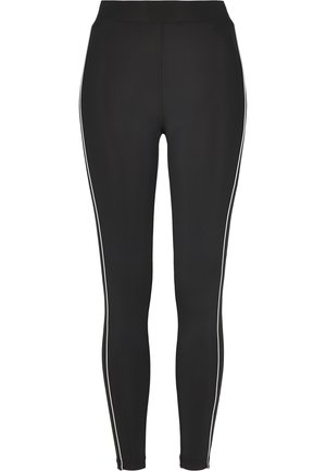 Črne legice iz raztegljivega materiala, z visokim pasom in belimi stranskimi črtami po nogah. Gladka tekstura, prilega se.