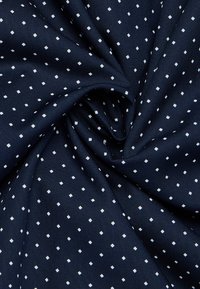 Tessuto blu navy con una texture liscia, caratterizzato da un motivo di piccoli diamanti bianchi distribuiti uniformemente.
