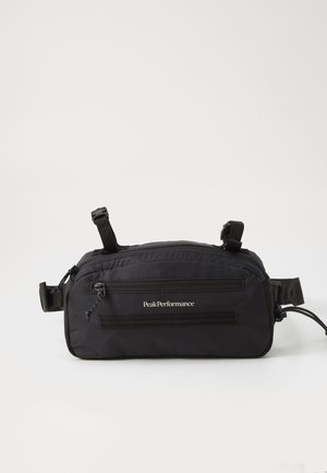 Sac à taille noir avec plusieurs zippers, sangles ajustables et une texture lisse. Présente un logo et un design pratique pour un transport facile.