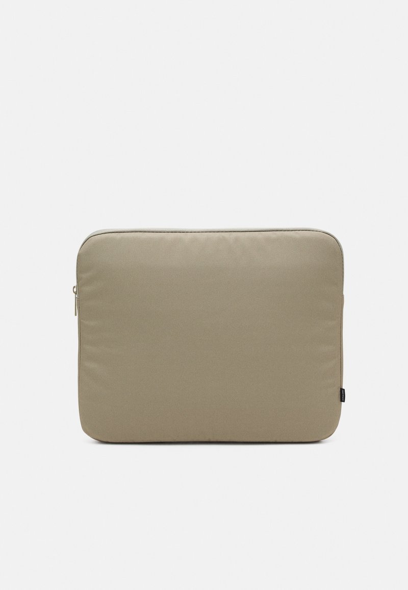 Housse d'ordinateur portable rectangulaire beige rembourrée avec coins arrondis et petite languette de fermeture éclair noire sur fond blanc.