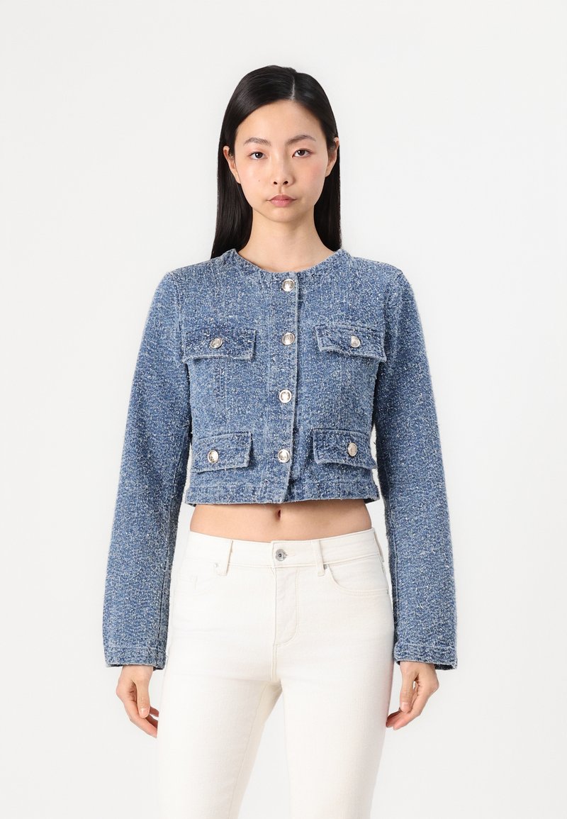 Blauwe tweed cropped jasje met lange mouwen, ronde halslijn, vier voorkiezen en zilveren knoopsluitingen. Getextureerde stof met variërende tinten.