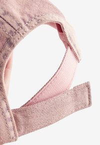 Rosa basebollkeps med en texturerad tygkonstruktion, mjukt innerfoder och justerbar rem för perfekt passform. Slitna detaljer finns.