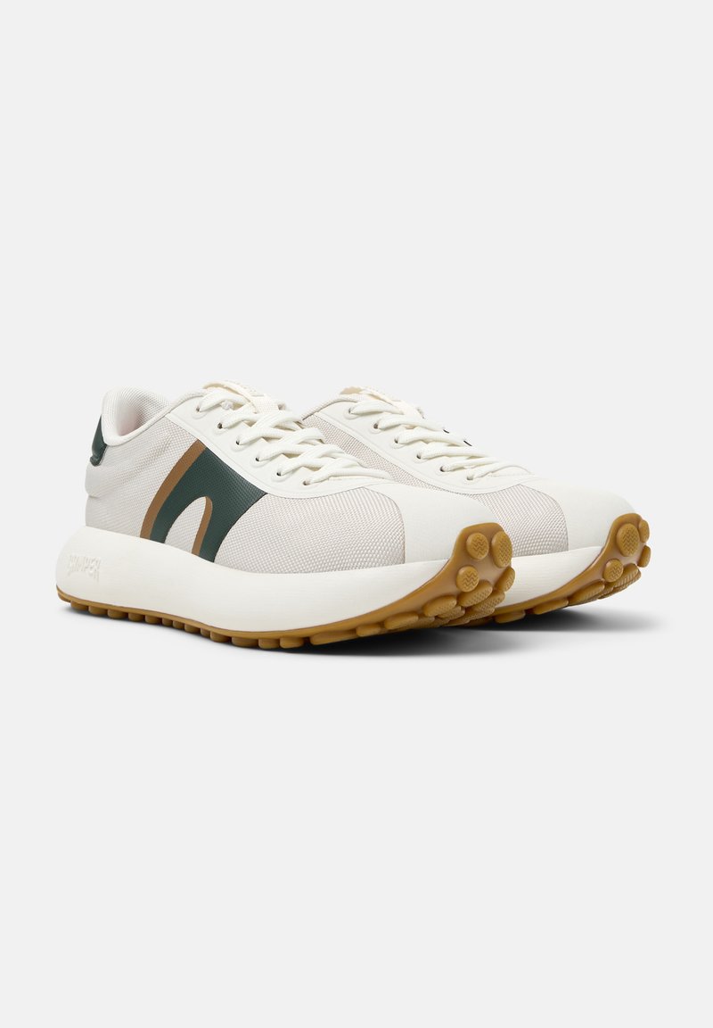 Helle Sneaker mit grünen und beige Akzenten, strukturiertem Stoff und einer Gummisohle mit runden Traktionsmustern.