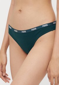 Groene katoen bikini slip met een elastische tailleband en een witte "PUMA" logo. Glad oppervlak en klassieke snit. Grensloos ondergoed ontwerp.
