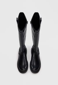 Black leather knee-high boots with rounded toes, flat soles, and vertical zip closures. Smooth texture, minimalistic design, no visible patterns.
