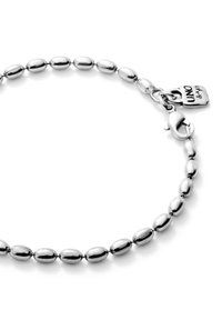 Bracelet en argent composé d'une série de maillons en forme d'ovale, texture lisse, avec un charm en forme de cadenas suspendu et une fermeture à ressort.