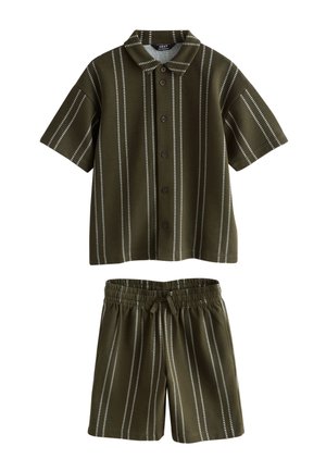 Oliwkowa krótka koszula na guziki z krótkim rękawem oraz pasujące szorty z elastyczną talią i białymi pionowymi przerywanymi paskami.