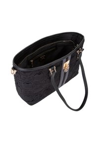 Sac fourre-tout en tissu noir avec un motif floral matelassé, comprenant une bande grise, une quincaillerie dorée et deux poignées. L'intérieur comporte plusieurs poches.