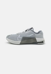 Nike athletic shoe featuring a gray mesh upper, a padded collar, a transparent midsole section, and textured rubber outsole.