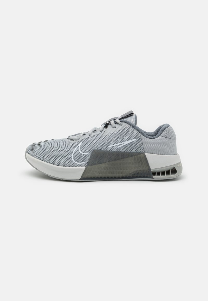 Nike athletic shoe featuring a gray mesh upper, a padded collar, a transparent midsole section, and textured rubber outsole.