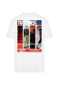 Weißes Baumwoll-T-Shirt mit einem farbenfrohen Grafikdesign auf der Rückseite, das Bilder und Texte von einem vintage TV-Magazin-Cover zeigt.