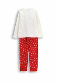 Biała bawełniana bluzka z długim rękawem z czerwonymi bawełnianymi spodniami dresowymi z białymi wzorami kwiatowymi na czerwonym tle i zwężanymi mankietami.