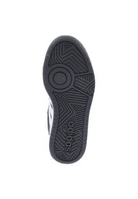 Suola di sneaker nera in gomma con motivo a spina di pesce testurizzato, dettaglio di presa circolare e marchio "adidas" stampato sul lato.