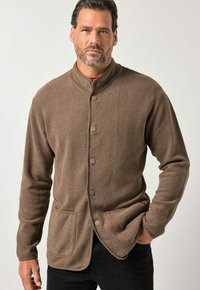 Brun cardigan med knapper, lavet af tekstureret stof med høj krave, to forlommer og kontrastfarvet kant langs kanterne.