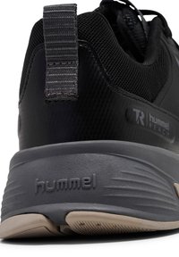 Zwarte sportieve schoen met bovenwerk van mesh, gevoerde hak en een gestructureerde rubberen zool. Voorzien van het merkembleem aan de zijkant en een verstevigde hielstrook.