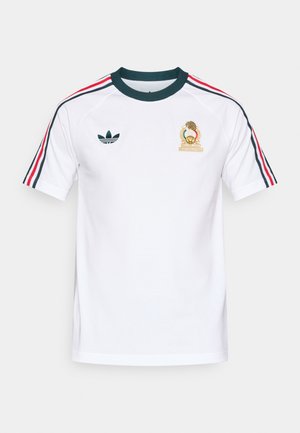 Camiseta de algodón blanca con cuello redondo acanalado en verde, con rayas rojas y azules en las mangas y un emblema dorado bordado en el pecho.