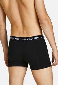 Schwarze Boxershorts mit einem weichen, elastischen Bund, der den Markennamen "JACK & JONES" in Weiß zeigt, schlankes Design, glatte Stofftextur.