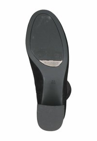Semelle de chaussure à talon haut en daim noir avec une finition lisse, présentant une légère courbure et un imprimé de marque. Semelle supérieure en caoutchouc antidérapante.