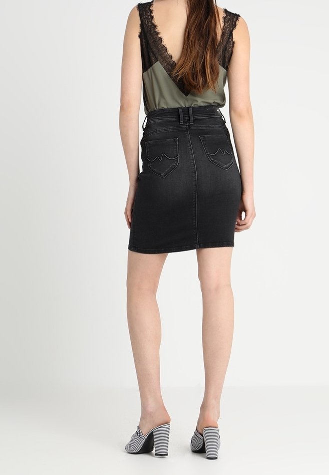 Černá džínová sukně s vysokým pasem a dvěma zadními kapsami, s přiléhavým střihem. Nošena s zelenou a černou krajkovou blůzou a pruhovanými mulemi.