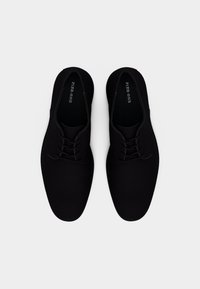 Μαύρα δερμάτινα παπούτσια με κορδόνια, με ομαλή υφή, στρογγυλεμένη μύτη και μίνιμαλ σχεδιασμό. Διαθέτουν ραμμένο άκρο και εσωτερική σήμανση.