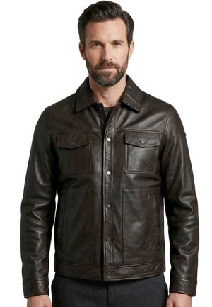 Mann mit kurzen dunklen Haaren und Bart, der eine dunkelbraune Lederjacke mit Klappentaschen auf der Brust und Druckknöpfen trägt und vor weißem Hintergrund steht.