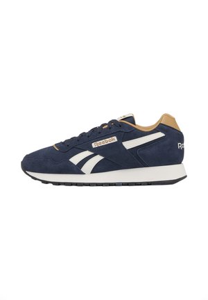 Baskets Reebok bleu marine et marron clair avec des rayures blanches sur le côté, modèle à lacets et semelle noire, vues de profil.