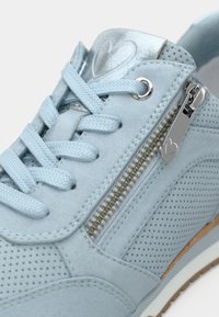 Ανοιχτό μπλε σουέτ αθλητικά παπούτσια με διάτρητο σχέδιο, γκρι μεταλλικές λεπτομέρειες, επίπεδα κορδόνια και πλευρικό φερμουάρ με ασημένια αξεσουάρ.