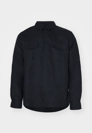 Langermet mørkeblå skjorte laget av et teksturert stoff, med knappelyse front, to brystlommer og klassisk krage.
