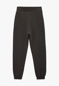 Mørkegrå joggerbukser lavet af blødt stof, med elastisk talje og samlede cuffs ved anklerne. Glat tekstur hele vejen igennem.