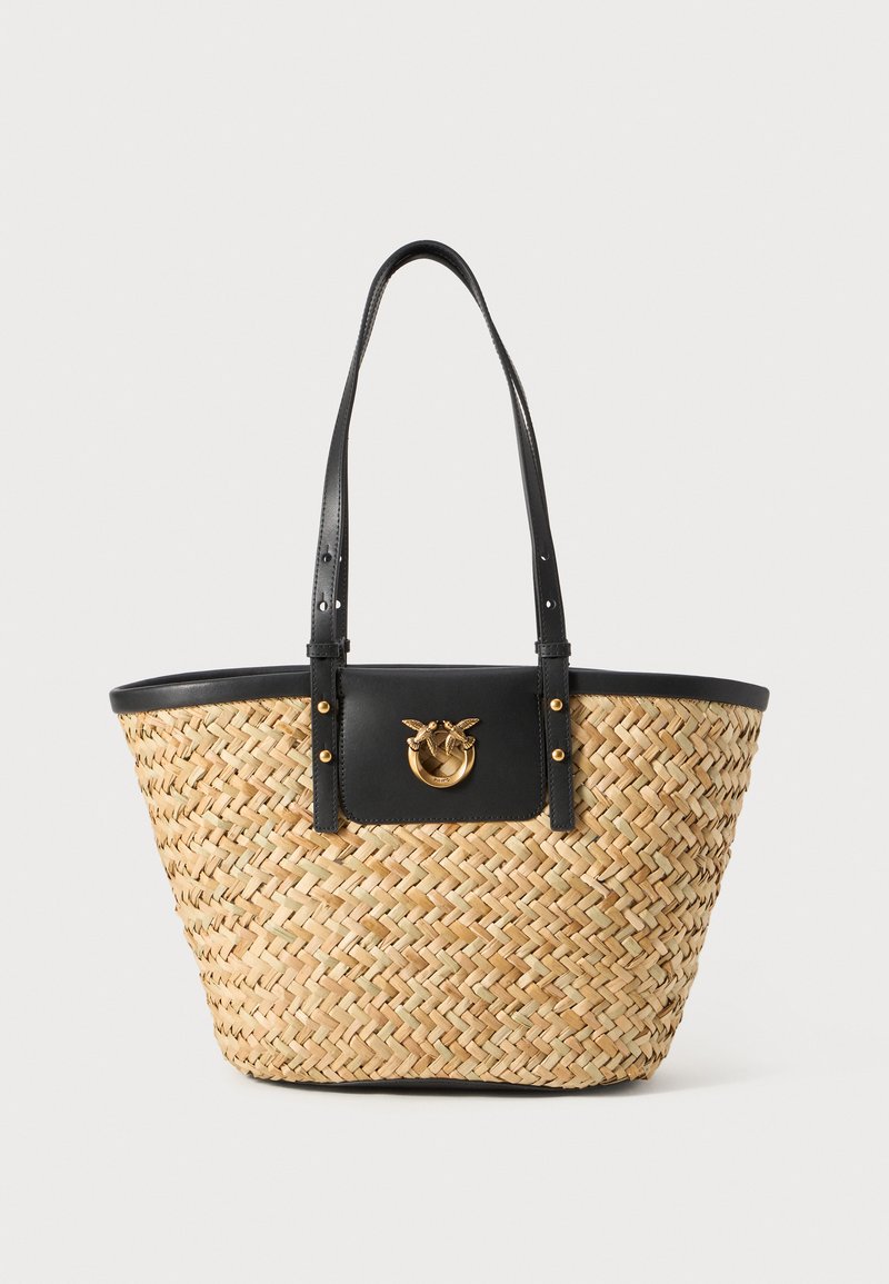 Bolsa tote de palha trançada com detalhes em pele preta. Apresenta duas alças de ombro e um fecho em forma de círculo dourado em um painel preto.
