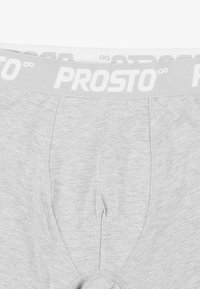 Szare męskie majtki z miękką elastyczną gumką w pasie z białym napisem "PROSTO", gładką fakturą i dopasowanym krojem.