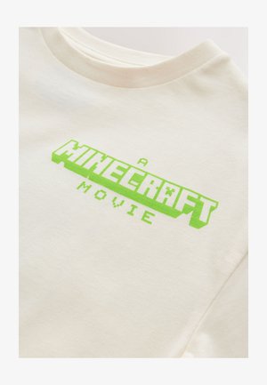 Weißes Baumwoll-T-Shirt mit einem leuchtend grünen, pixeligen "A MINECRAFT MOVIE"-Grafikdruck, rundem Ausschnitt und kurzen Ärmeln.