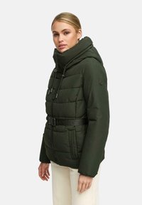 Giacca a vento verde scuro, con colletto alto, cappuccio staccabile e cintura. Presenta un design trapuntato e una cerniera frontale con tiranti.