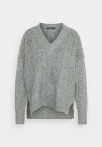 Grauer Strickpullover mit V-Ausschnitt, der ein strukturiertes Zopfmuster und einen gerippten Saum aufweist. Lange Ärmel in lockerer Passform mit seitlichen Schlitzen.