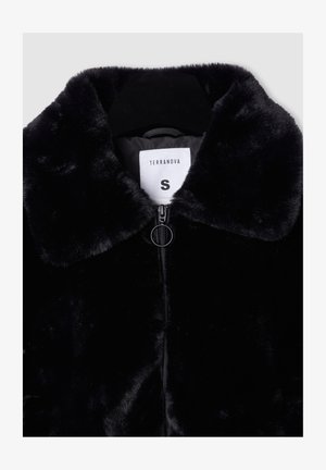 Giacca in pelliccia sintetica nera con colletto arrotondato, chiusura a zip e un'etichetta con la scritta "TERRANOVA" taglia "S". La texture appare morbida e pelosa.