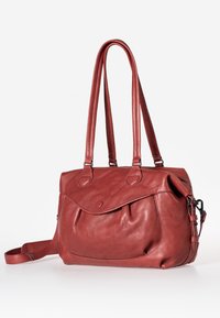 Red leather handbag with two shoulder straps, rounded shape, and a front pocket with a flap. Smooth texture with subtle stitching details.