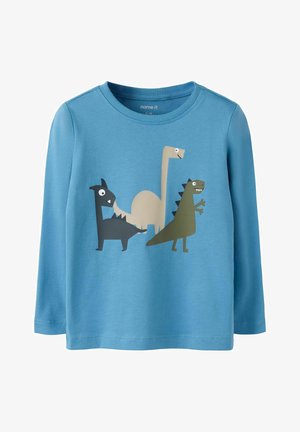 Blå langærmet skjorte til småbørn med tre tegneserie-dinosaurer i sort, beige og grøn trykt på forsiden.