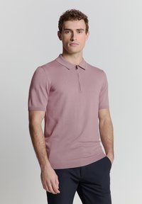Korte mouwen polo shirt van zacht roze breiwerk met een kraag en een halve ritssluiting. Heeft ribgebreide randen en een getailleerd ontwerp.