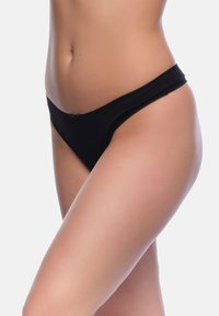 Schwarze Tangas aus elastischem Stoff, mit einer glatten Textur und einem minimalen Schnittdesign sowie einem einfachen Bund.