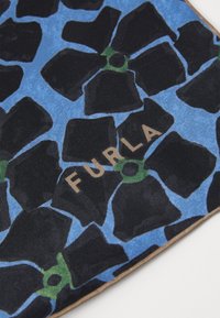 Materialul Furla cu un model floral, având petale negre pe un fundal albastru, accentuat de detalii verzi și litere aurii.