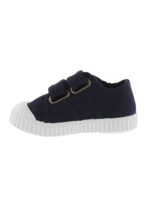 Baskets pour enfants en toile marine avec deux brides ajustables, embout en caoutchouc blanc et semelle texturée blanche. Design bas standard.