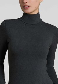Maglione grigio a maniche lunghe con collo alto, dal design aderente, texture liscia e leggera costina sul colletto. Caratterizzato da un collo alto e aderente.