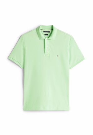 Polo de color verde claro hecho de una tela suave. Presenta una tapeta de tres botones y un pequeño logo en el lado izquierdo del pecho. Manga corta.