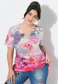Camiseta de manga corta con escote en V que presenta un diseño floral multicolor con elementos textuales, confeccionada en tejido ligero y con un corte relajado.
