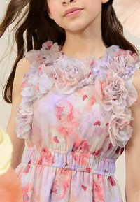 Abito con motivo floreale, in tessuto trasparente e arricciato sulle spalle, color rosa e viola pastello, vita elastica e leggerezza al tatto.