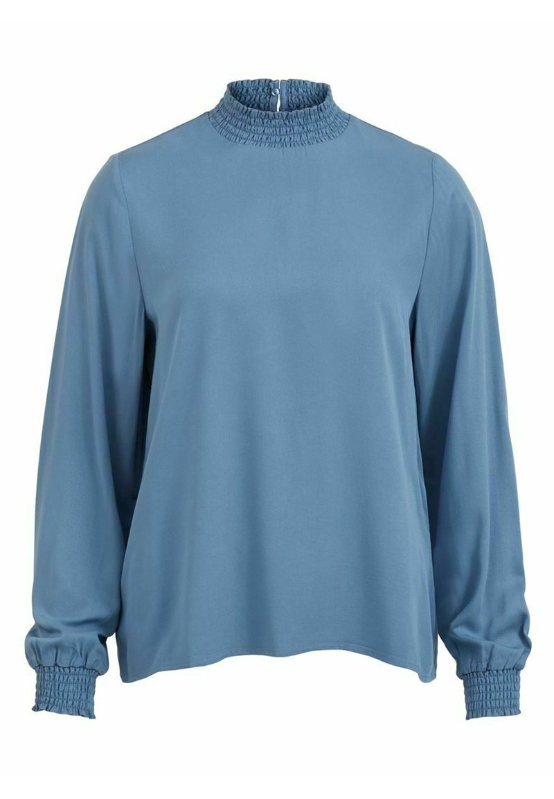 Modrý dlouhý rukáv s vysokým smockovaným límcem, nařasenými manžetami a uvolněným střihem. Hladká textura, minimalistický design. Zapínání na zip na zádech.