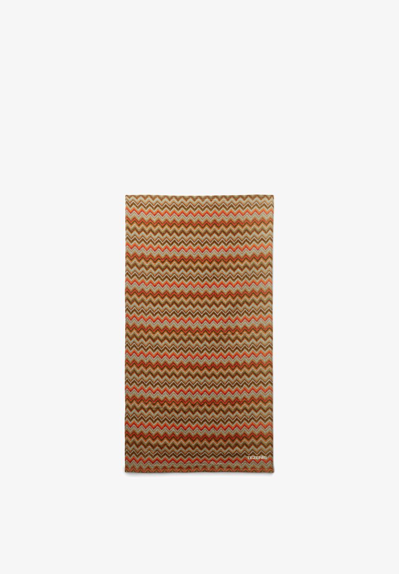 Textil rectangular con patrón de zigzag multicolor en tonos tierra, con franjas naranjas, marrones, beige y azul claro.