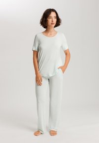 Conjunto de loungewear de color verde claro con una camiseta de manga corta y pantalones a juego. La tela parece suave, con un ajuste relajado y un diseño sencillo.