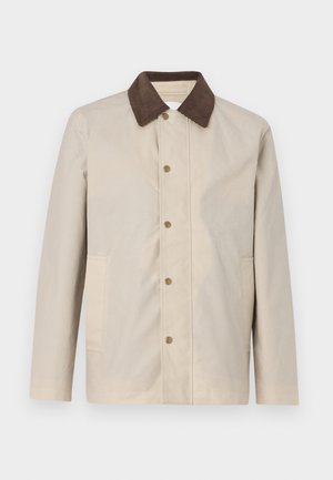 Casaco bege em material leve, com um colarinho de algodão escuro e frente com botões, incluindo dois bolsos laterais.