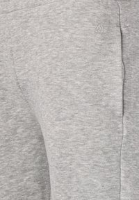 Graue Sweatpants aus weichem Material mit einem dezenten strukturierten Muster, seitlichen Taschen und einem Logoakzent nahe dem Bund.